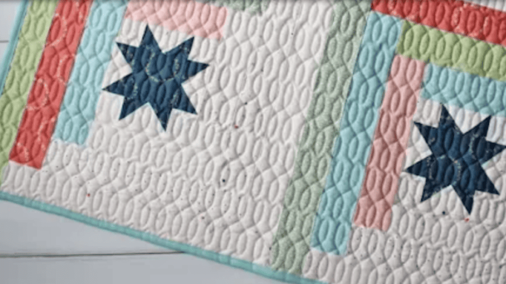 jelly roll quilt with blue star and ink, blue and green strips of fabric