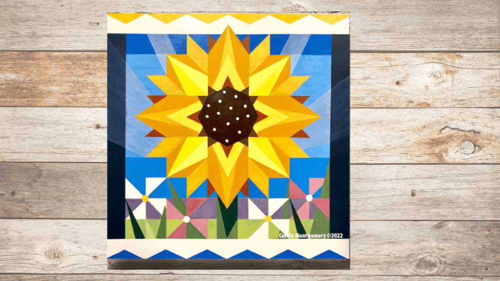 sunflower barn quilt with blue sky and yellow sunflower. Used to teach you how to make a barn quilt