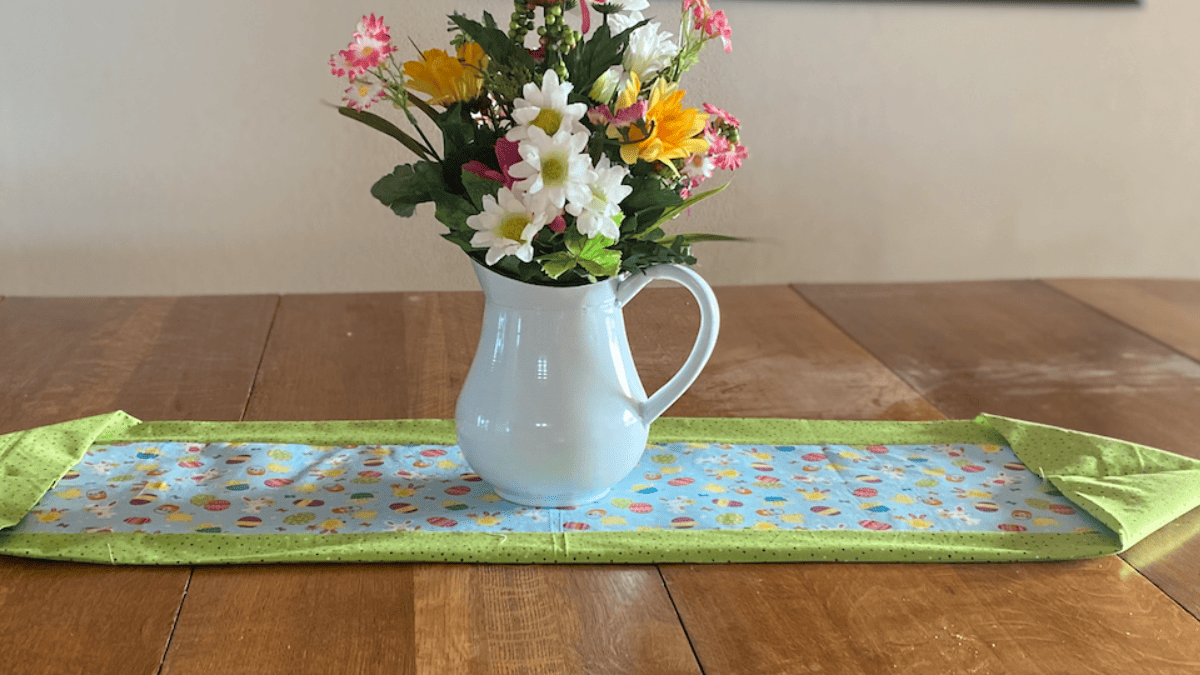 easter table runner with green poka dotted fabric as border and easter fabrric in center