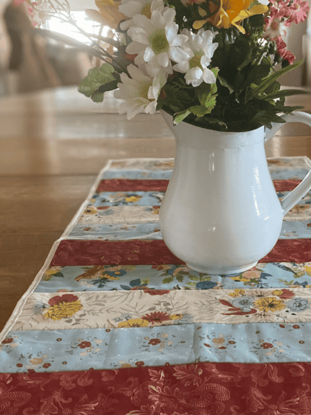 quilted table runner with strips of red, yellow blue and cream. Great quilt as you go table runner