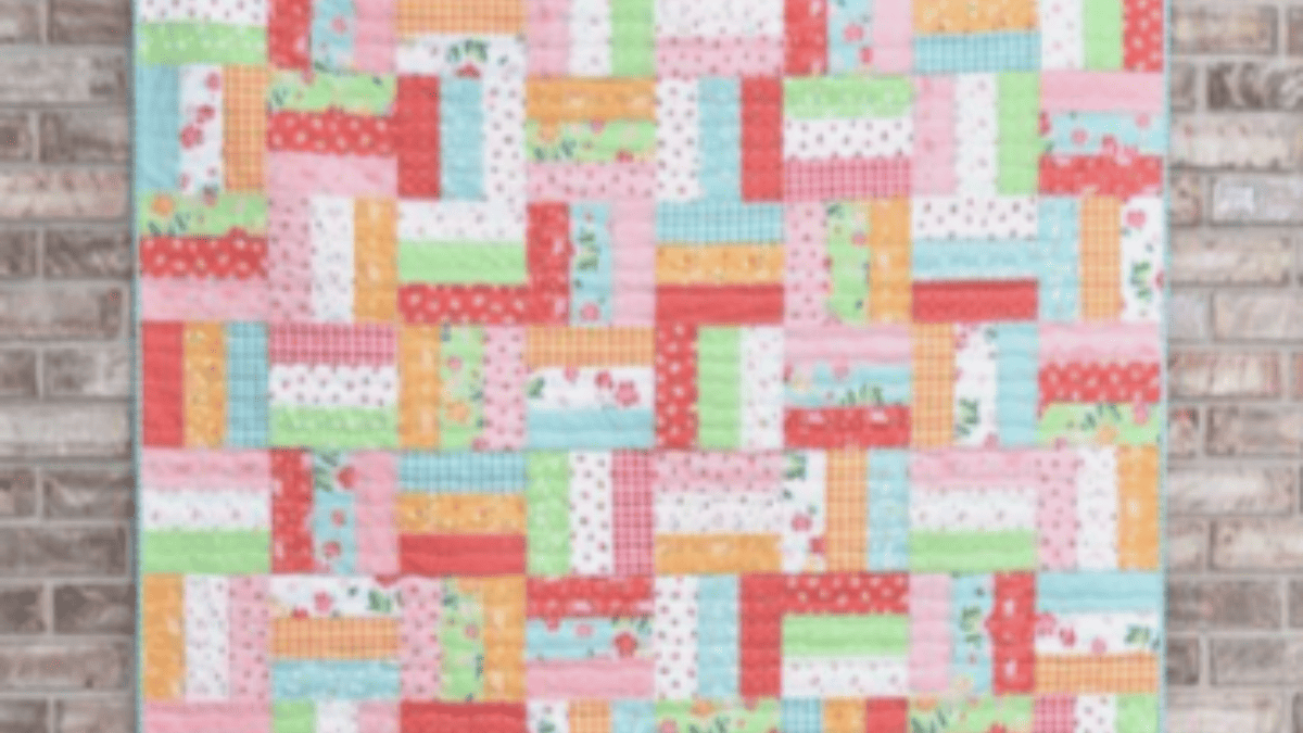 Jelly roll rail fence quilt with pinks, oranges, green and cream squares