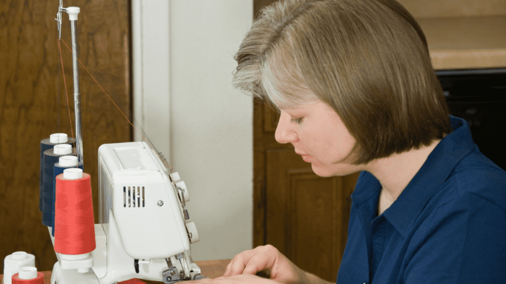 woman sewing on a serger with red thread showing how to use a serger