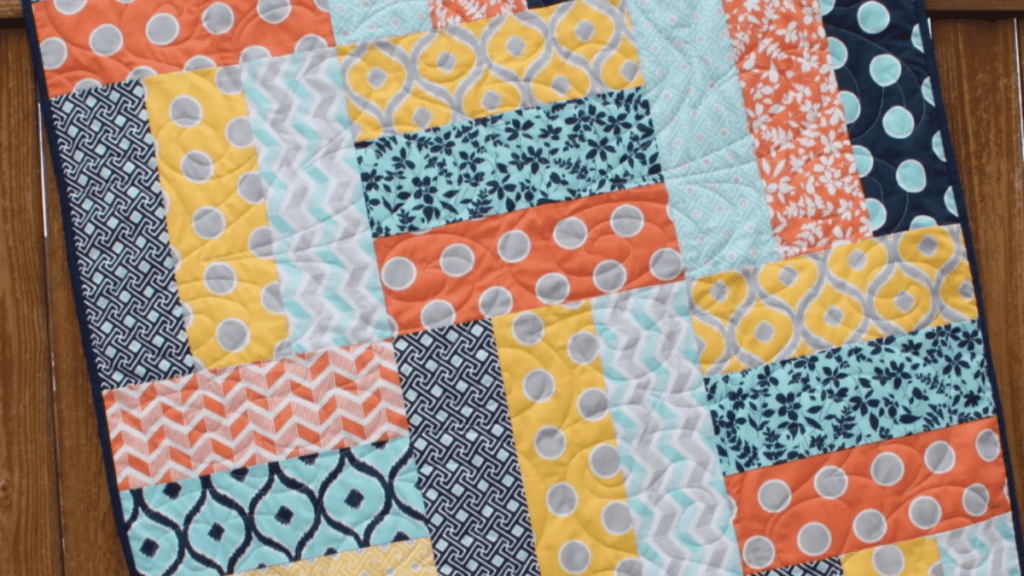 yellow, orange, blue and grey fabrics that make up a 3 yard quilt patterns quilt