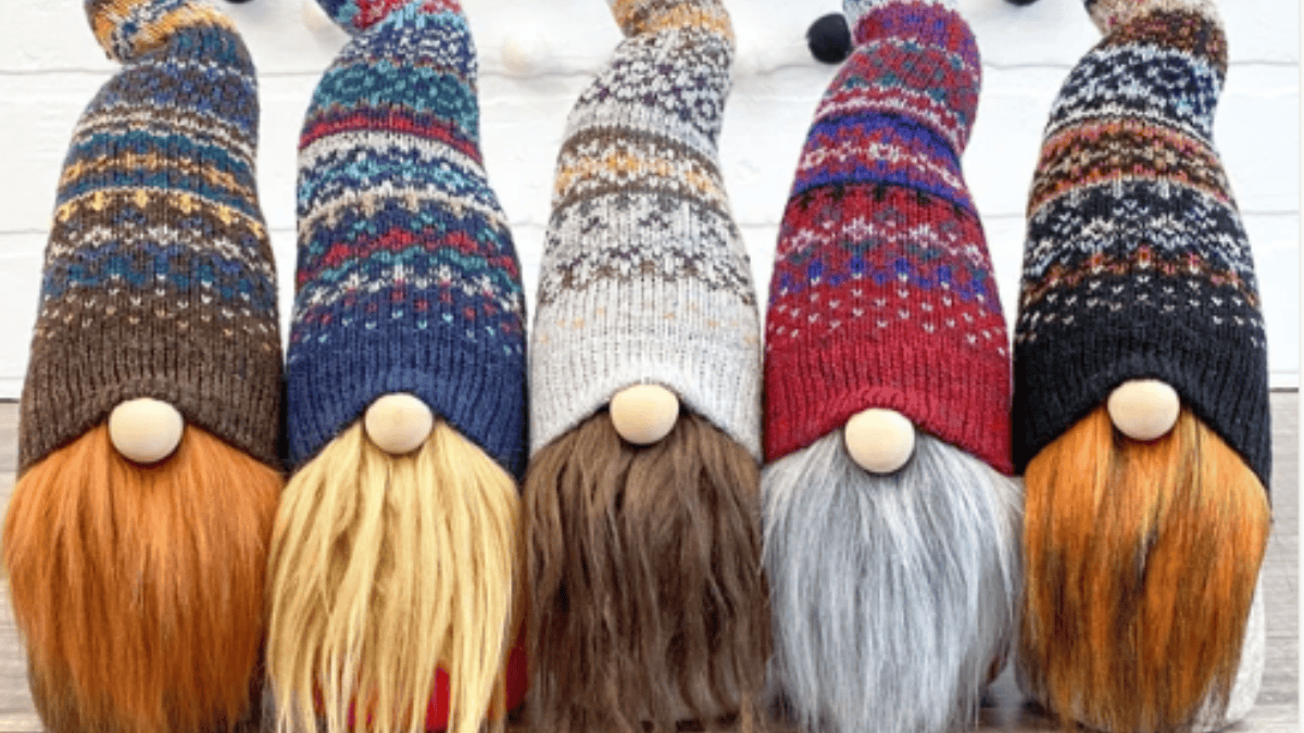 A group of everyday gnomes featuring a variety of colorful pointed hats and beards. Each gnome has a simple, stuffed cone-shaped body, creating a cheerful and diverse display of whimsical characters.